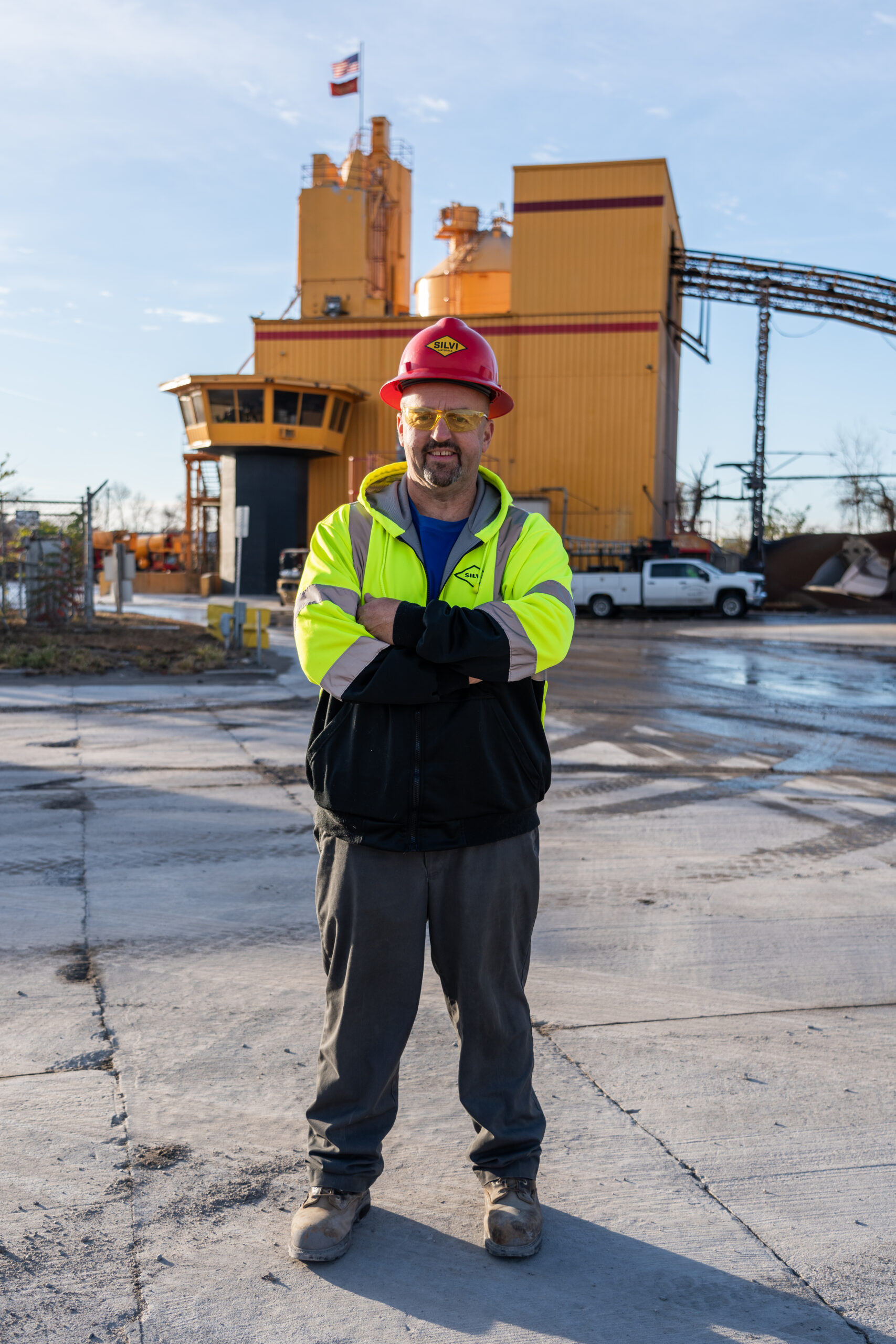 A photo of Silvi Materials' driver Michael Welsh standing outside of a concrete plant.